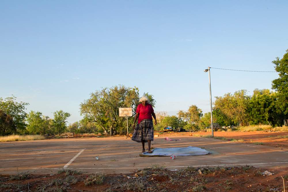 Bernadette Williams prepares a place to sit and yarn in the shade on the basketball court. Bernadette Williams prepares a place to sit and yarn in the shade on the basketball court.