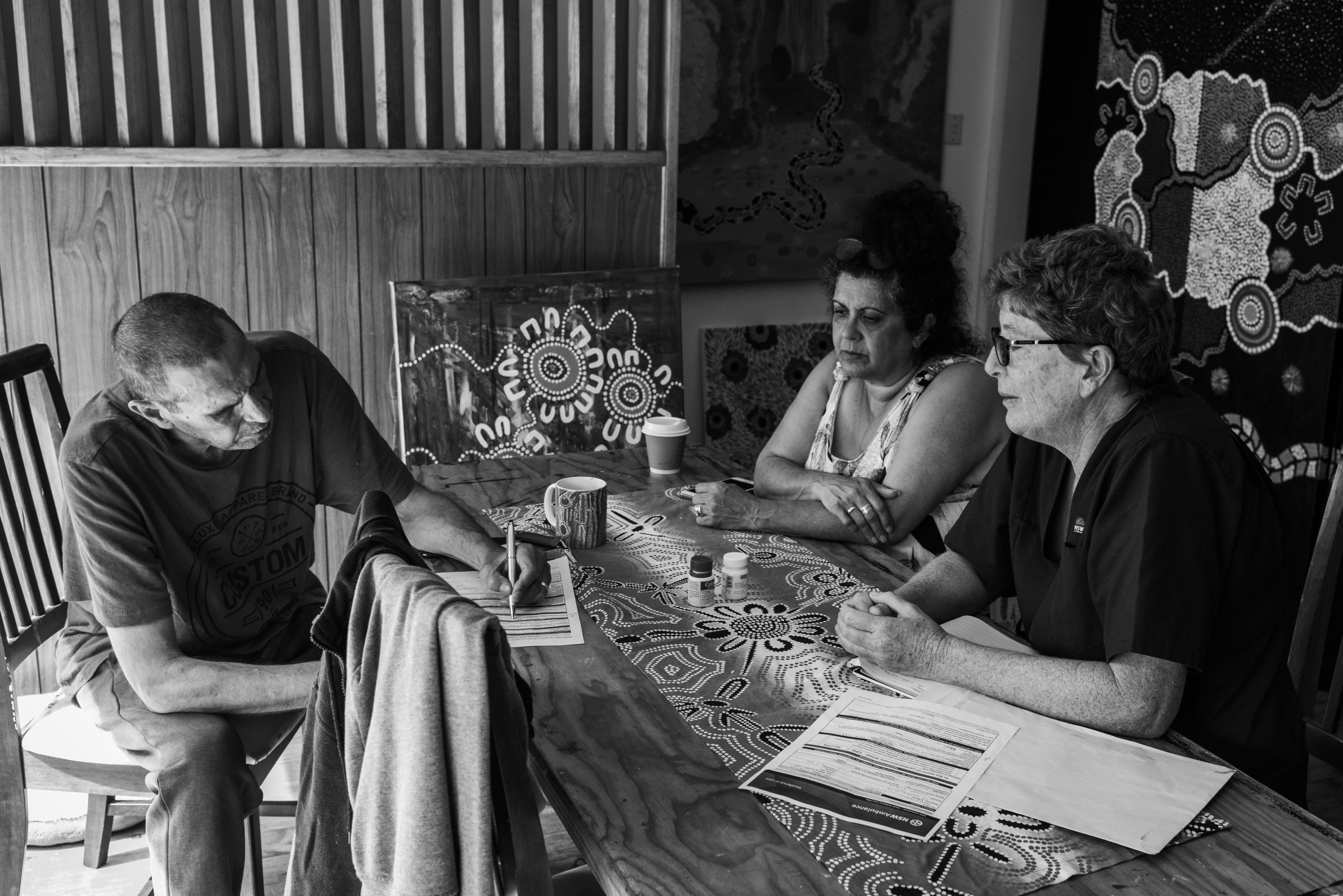 Jude Graham (RN, NSW Health Eurobodalla Community Services), watches as Glen records his choice to not be resuscitated if required. It is one of many difficult discussions that occur in palliation care but allows Glen to control what happens to him and health services to respect his choices. 17 January 2019. Yuin Country (Central Tilba, NSW).