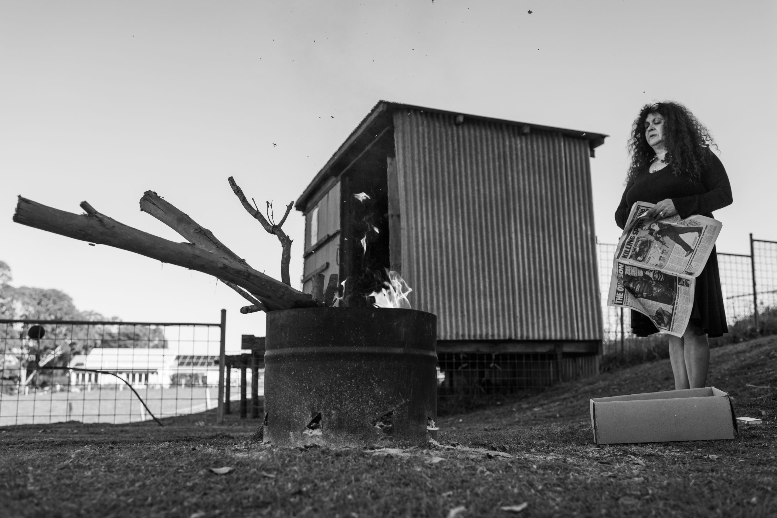 Merryn lights a fire for Glen the night before she leaves Tilba. 18 May 2019. Yuin Country (Central Tilba, NSW).