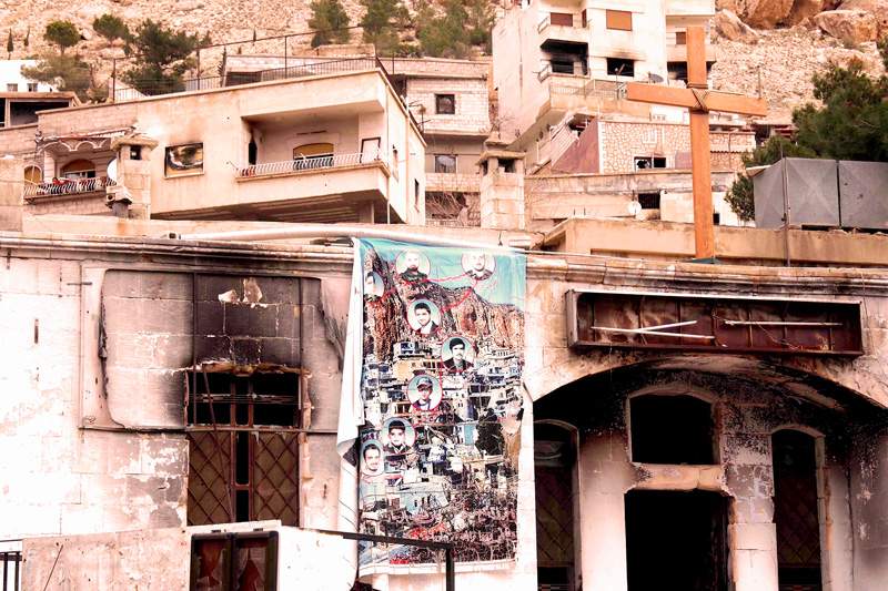 A burnt-out Syrian church displays a memorial banner to civilians killed in an attack. A burnt-out Syrian church displays a memorial banner to civilians killed in an attack.