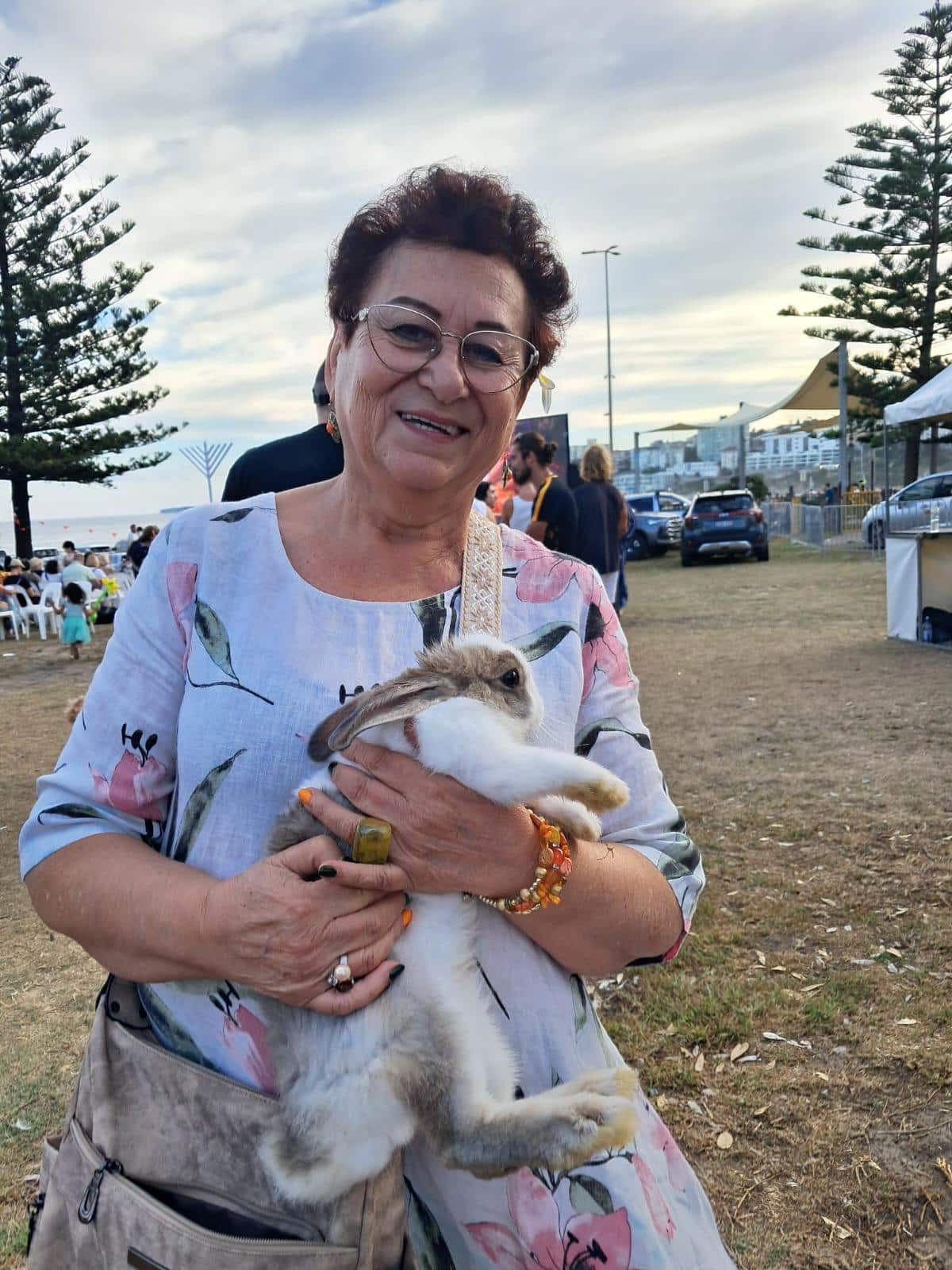 A woman holding a rabbit on Bondi beach