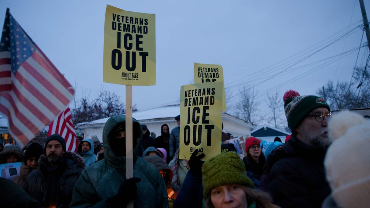 Portestors hold American flags and yellow signs reading 'Veterans Demand ICE OUT'.