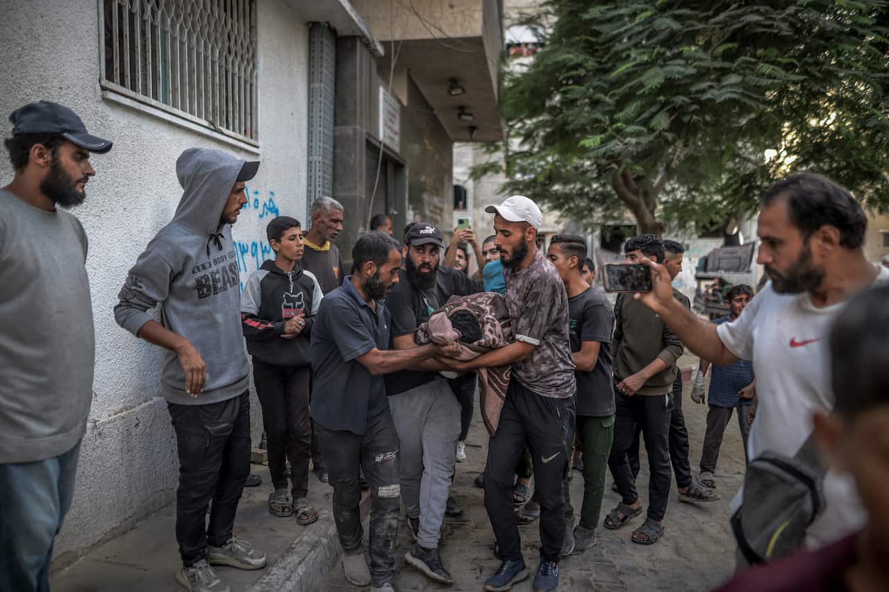 A group of Palestinians carrying the body of a person in a street