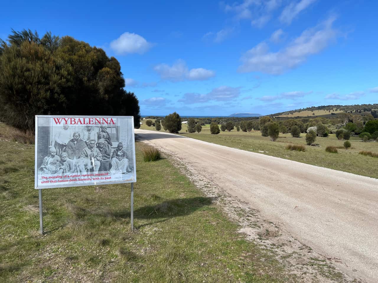 Un letrero que lee a Wybalenna al lado de un camino rural