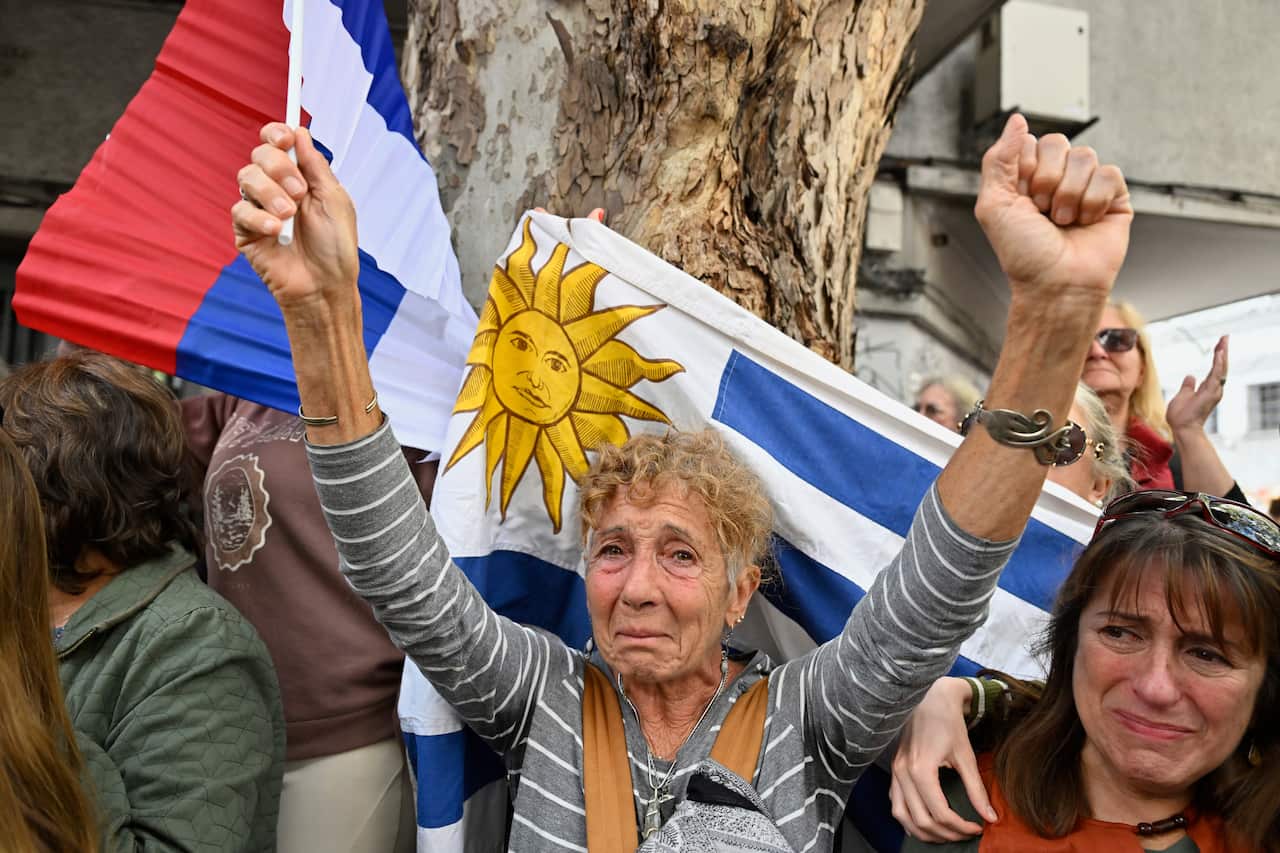 I presenti in lutto osservano la bara dell'ex presidente uruguaiano José Mujica.