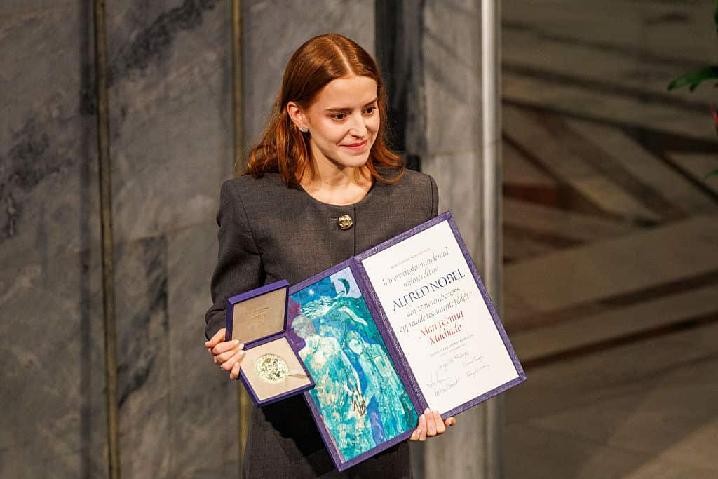 A woman holding a large certificate and a medal in a case