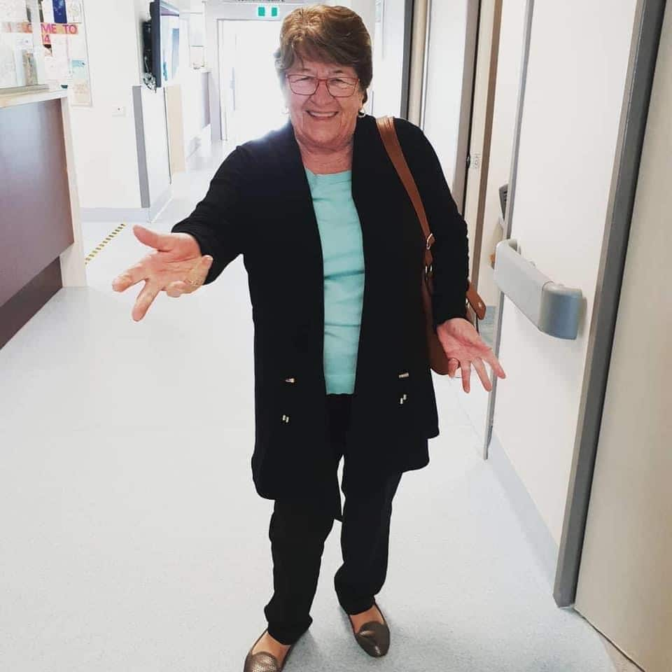 A woman is seen smiling in a hospital corridor. 