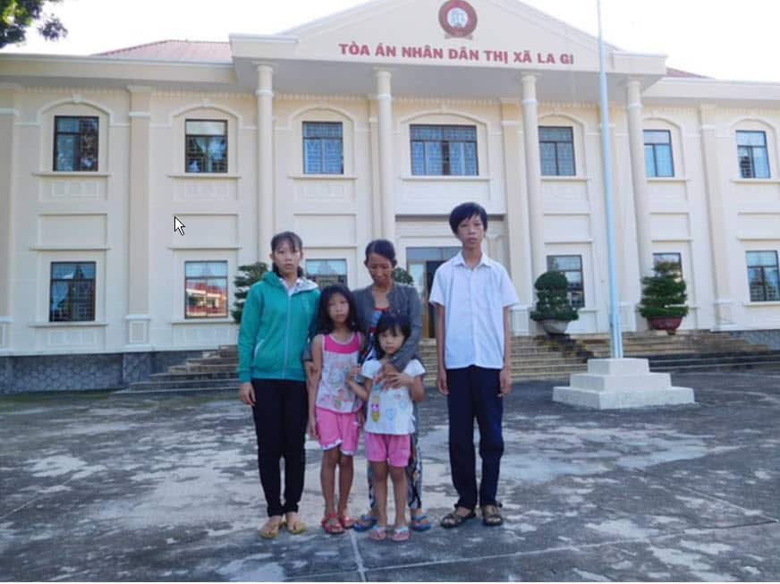 Tran Thi Thanh Loan and her children in front of the Court House.jpg