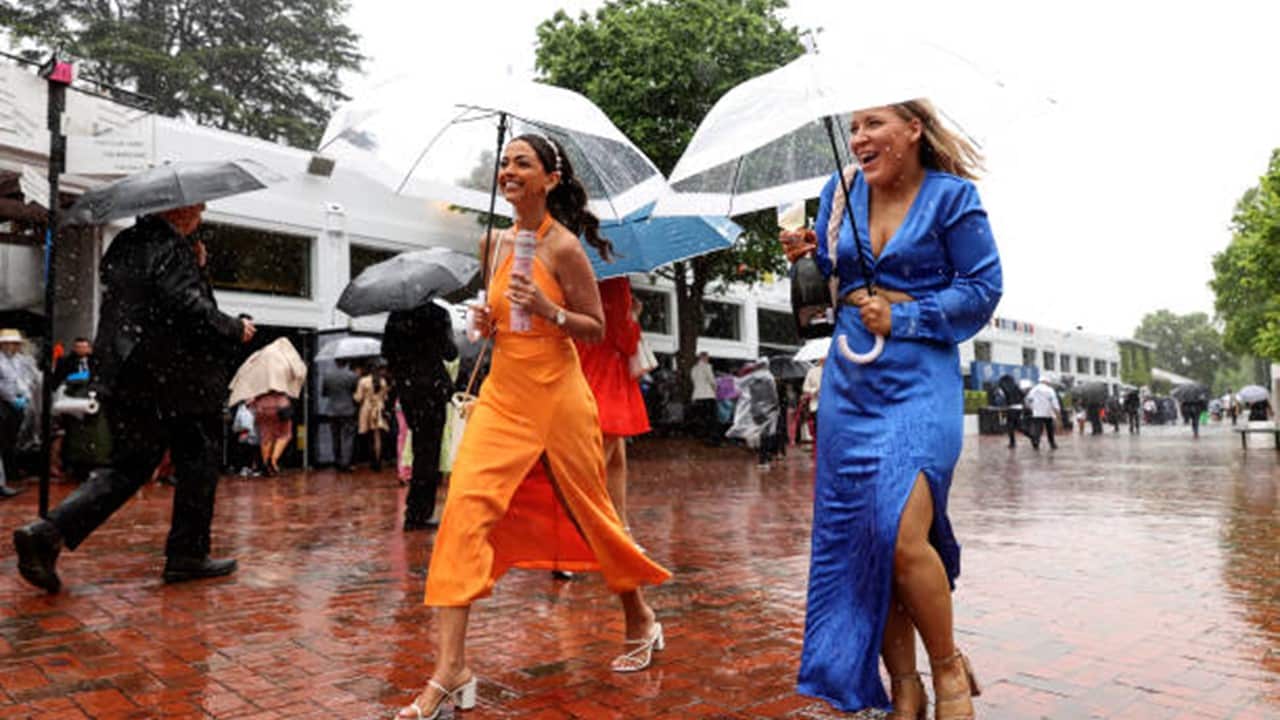 Racegoers brave the rain during 2022 Melbourne Cup Day at Flemington Racecourse.jpg