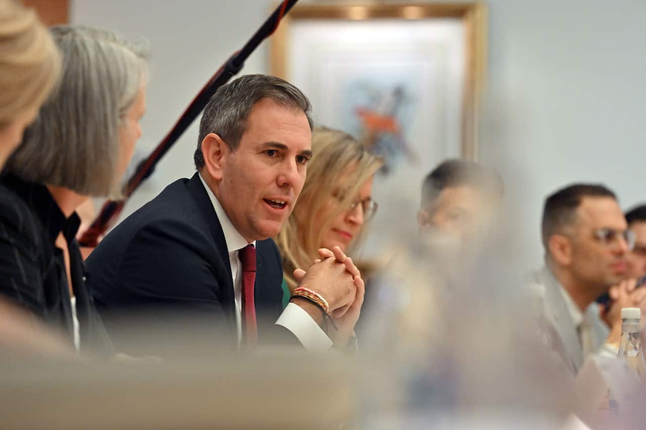 A man in a suit speaks at a roundtable conference