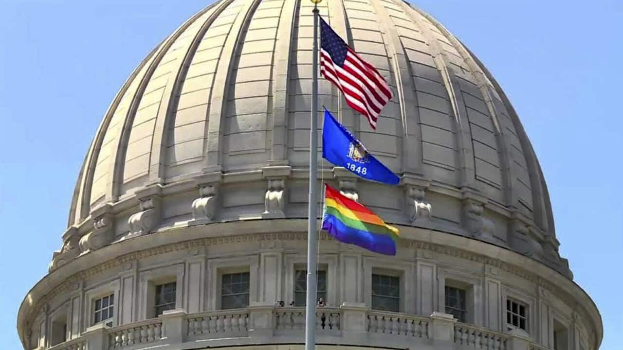 A rainbow flag observing Pride Month is displayed over the east wing of the Wisconsin State Capitol. But embassies will be banned from flying the [ride flag.