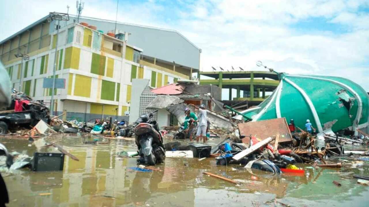 People survey the damage following a massive earthquake and tsunami in Palu, Central Sulawesi, Indonesia, Sunday