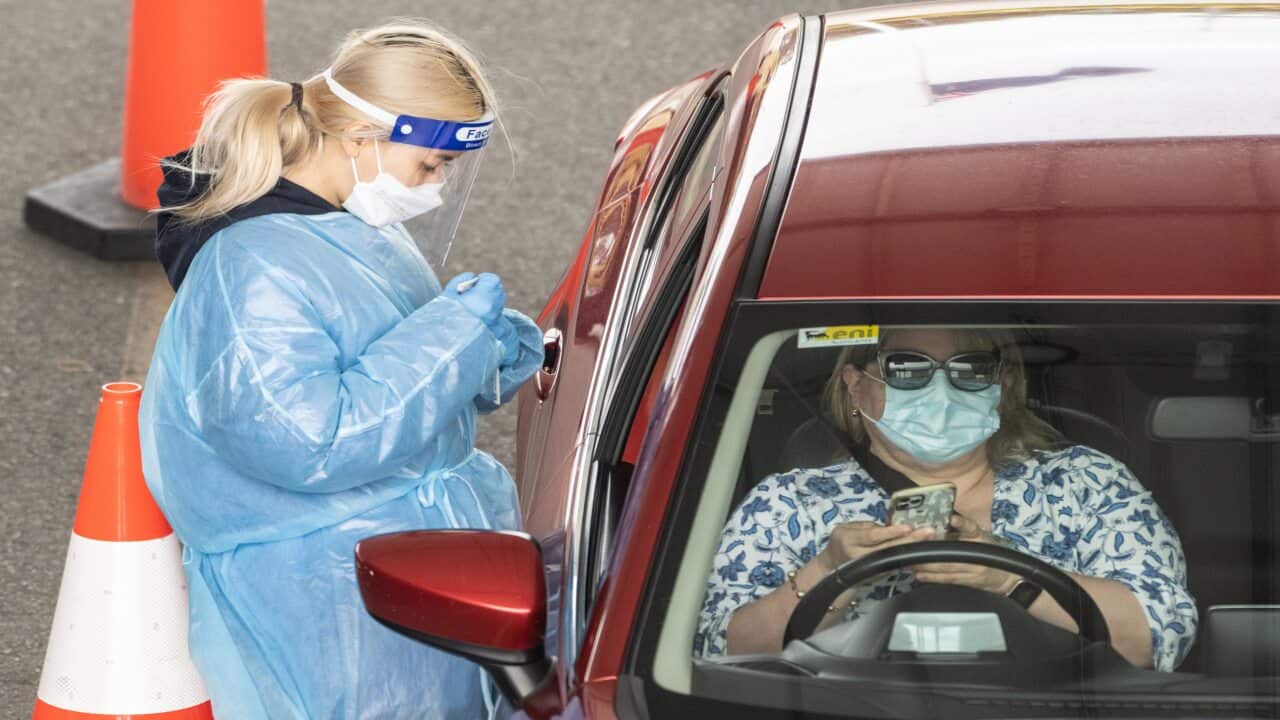 Healthcare workers adminstering COVID-19 tests at a drive through test centre in Sydney,