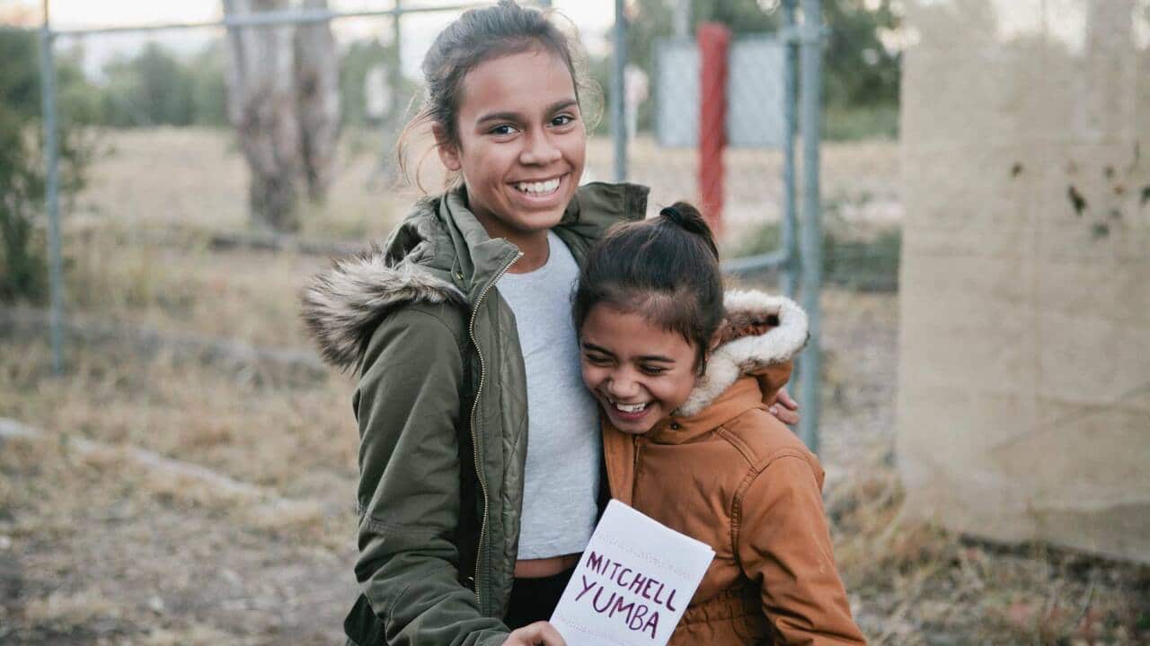 Miss Shilo Bligh and Miss Stella Bligh hold the Mitchell Yumba Sign after today's Federal Court decision