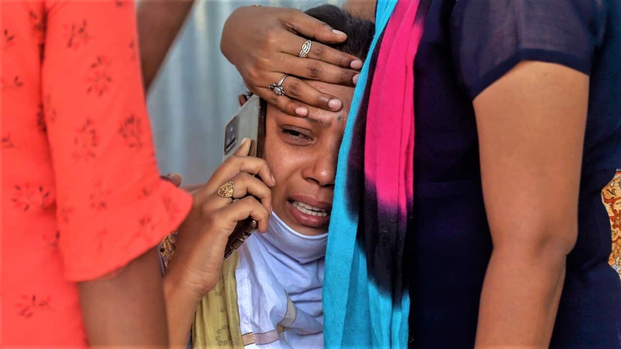 Relatives of a person who died of COVID-19 mourn outside a field hospital in Mumbai, India.