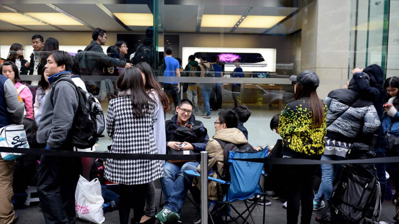 Customers wait in line to purchase the new iPhone 6 and iPhone 6+