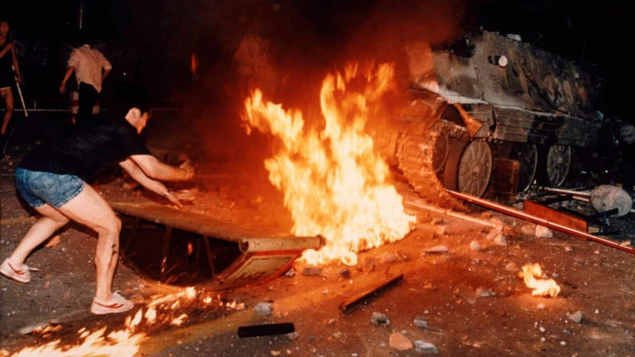 A student protester puts barricades in the path of an already burning armoured personnel carrier during anti-government protests in Beijing's Tiananmen Square in 1989.
