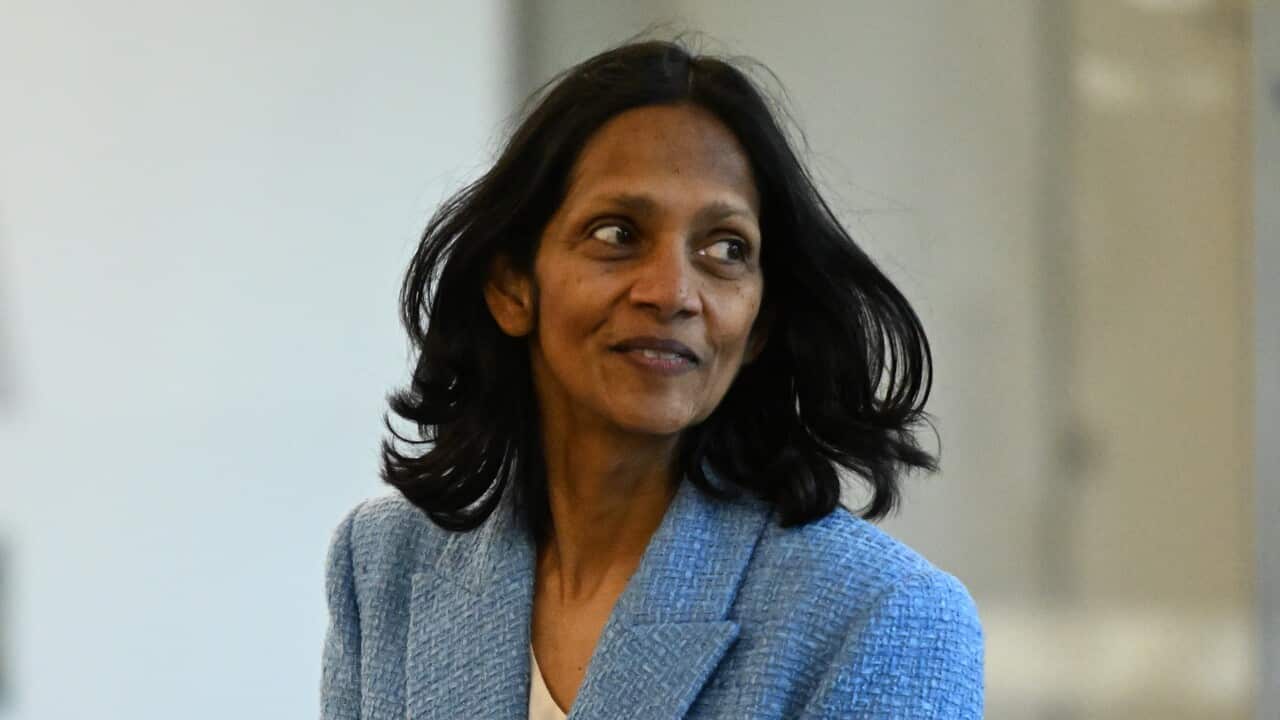 A woman wearing a blue blazer is looking sideways.