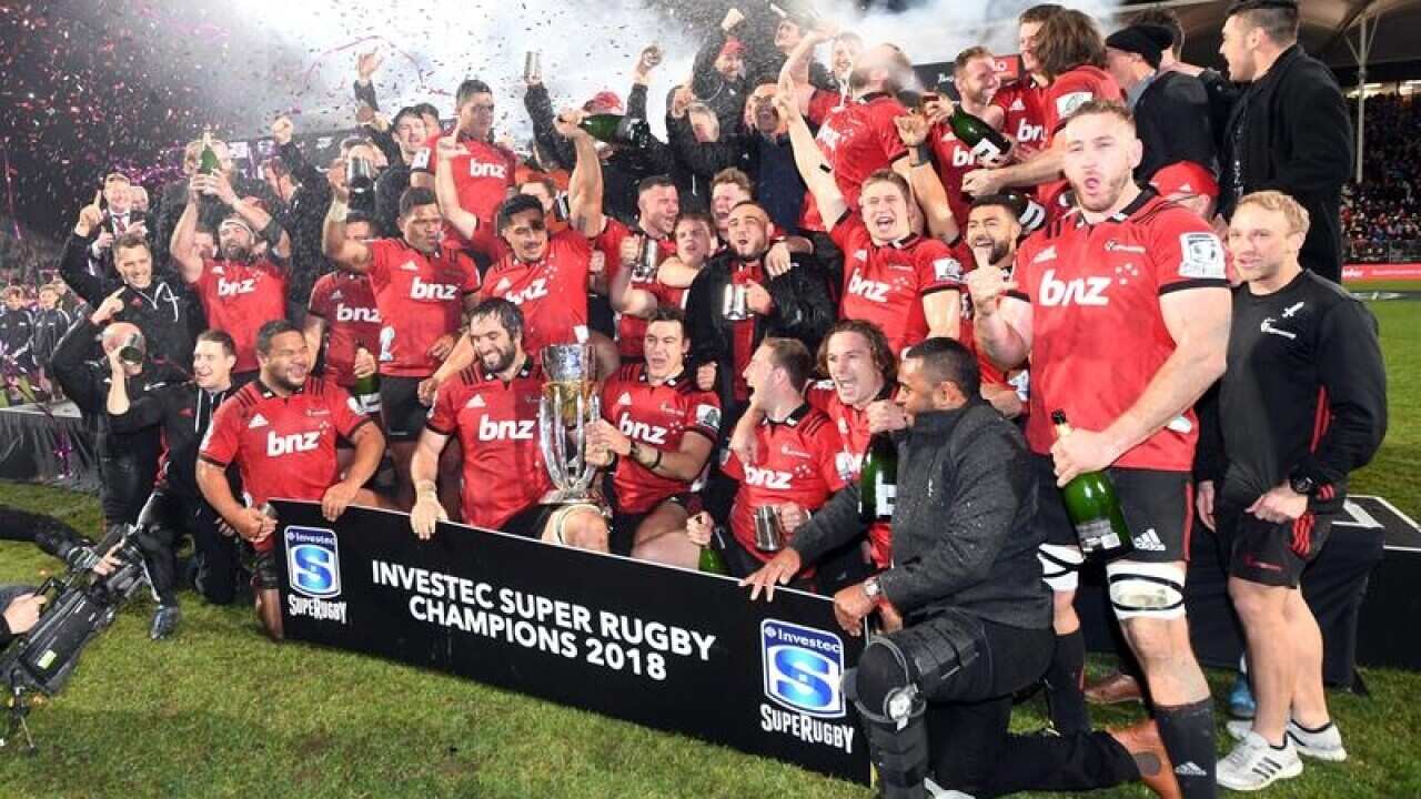 Crusaders players and coaching staff celebrate with the trophy