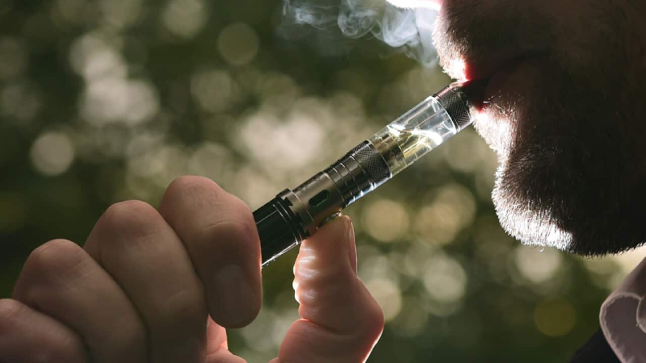 a man smoking an electronic cigarette