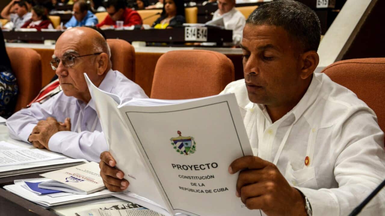 A member of the National Assembly studies the proposed update to the Constitution, in Havana.
