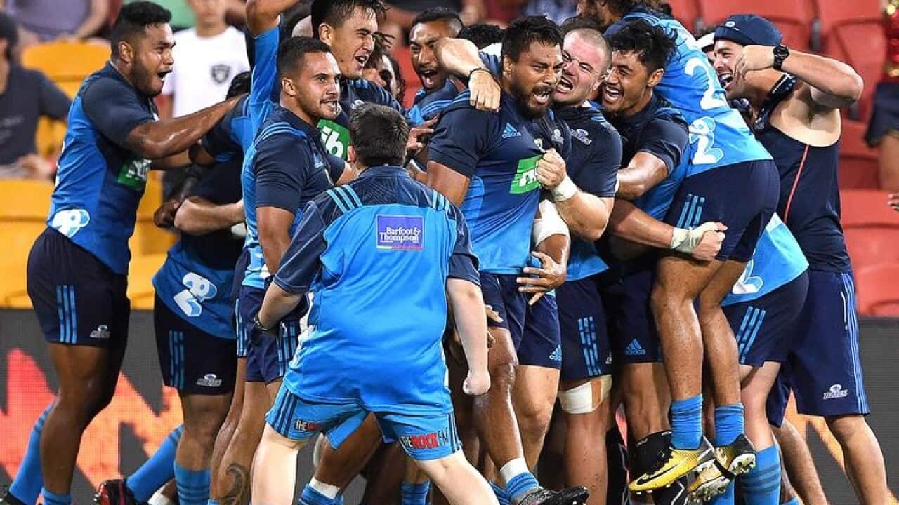 Blues players celebrate after George Moala (C) scored the winning try
