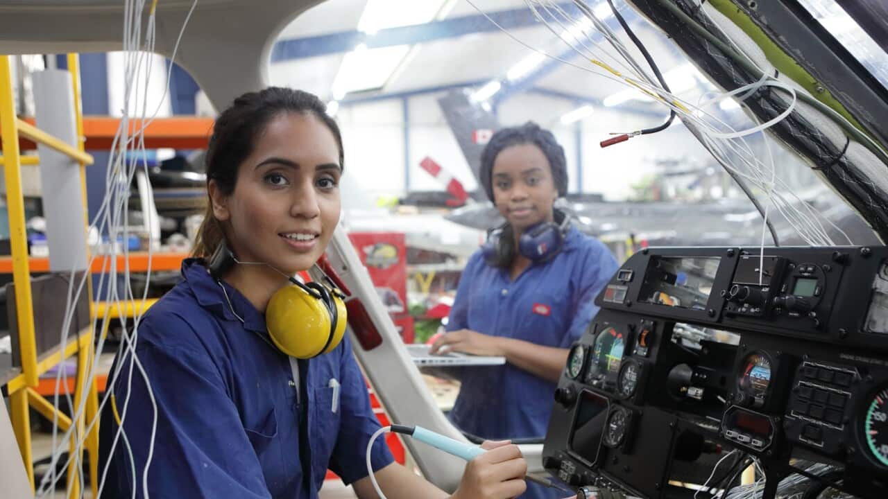 Young female engineers working with helicopters