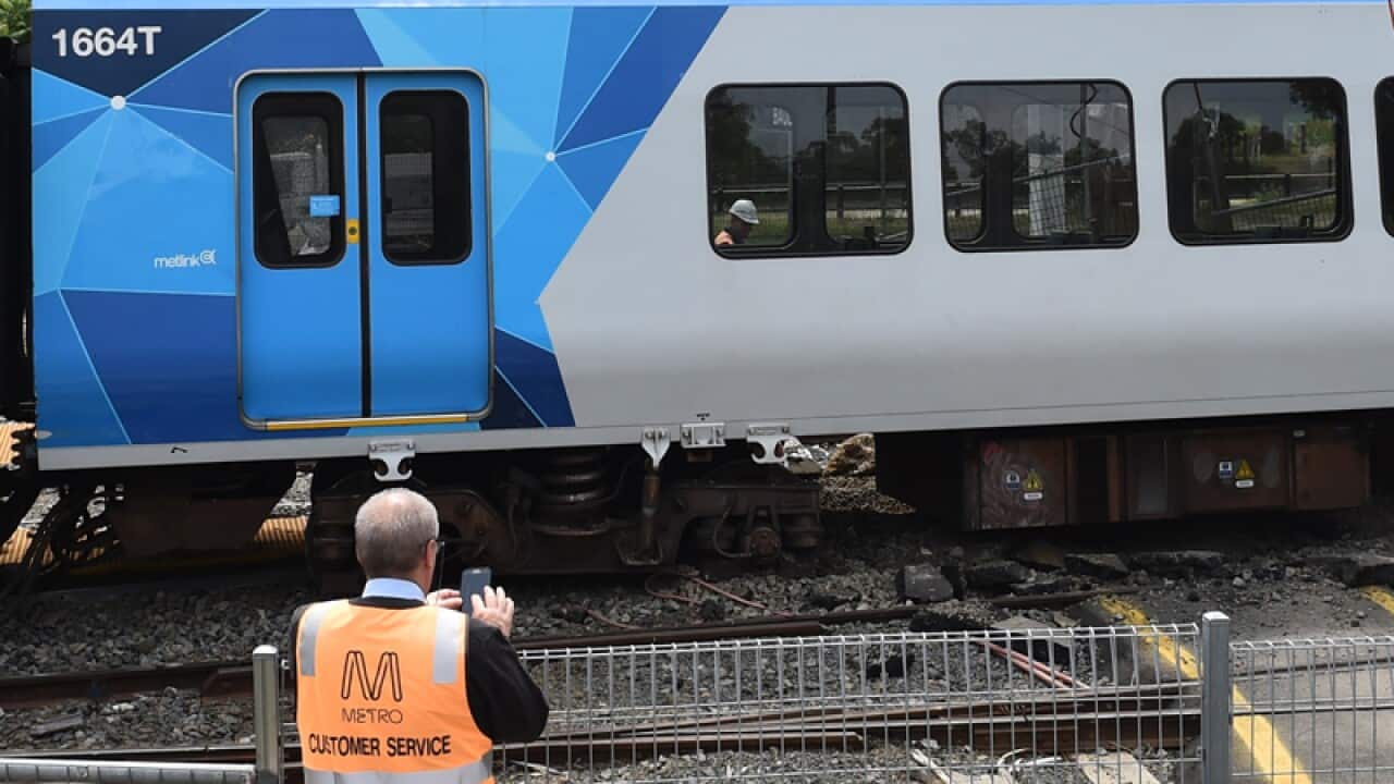 A Metro worker oversees the scene of a train derailment