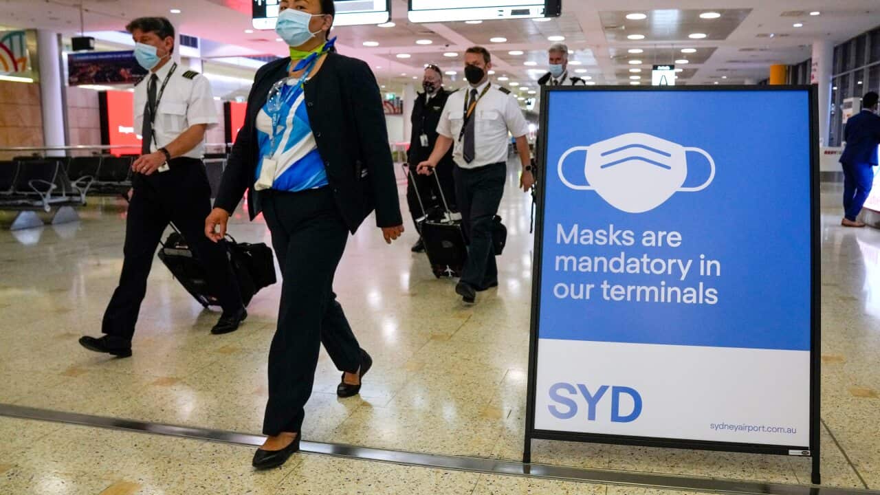 A flight crew walk through the terminal at Sydney Airport on 29 November, 2021.
