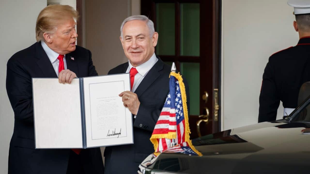 President Donald Trump and Israeli Prime Minister Benjamin Netanyahu hold up a signed proclamation.