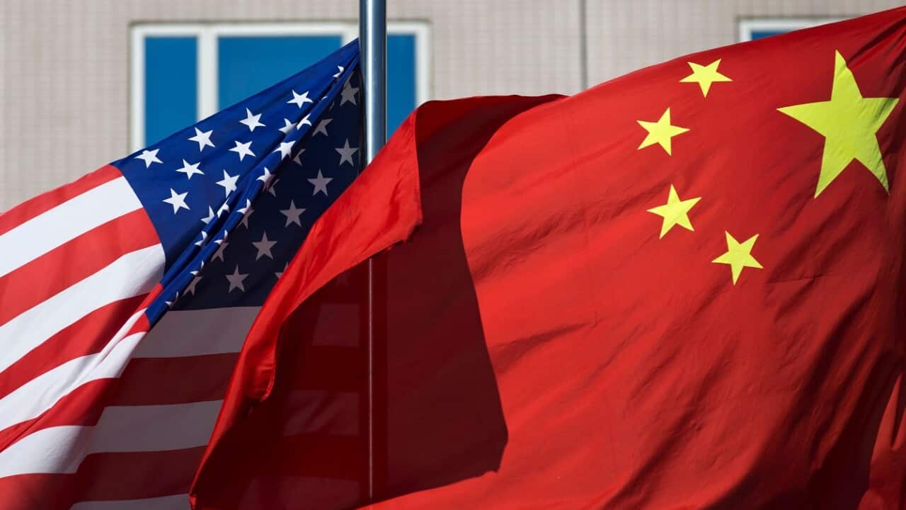 In this Sept. 5, 2012, file photo, U.S. and China's national flags flutter in winds at a hotel in Beijing. 