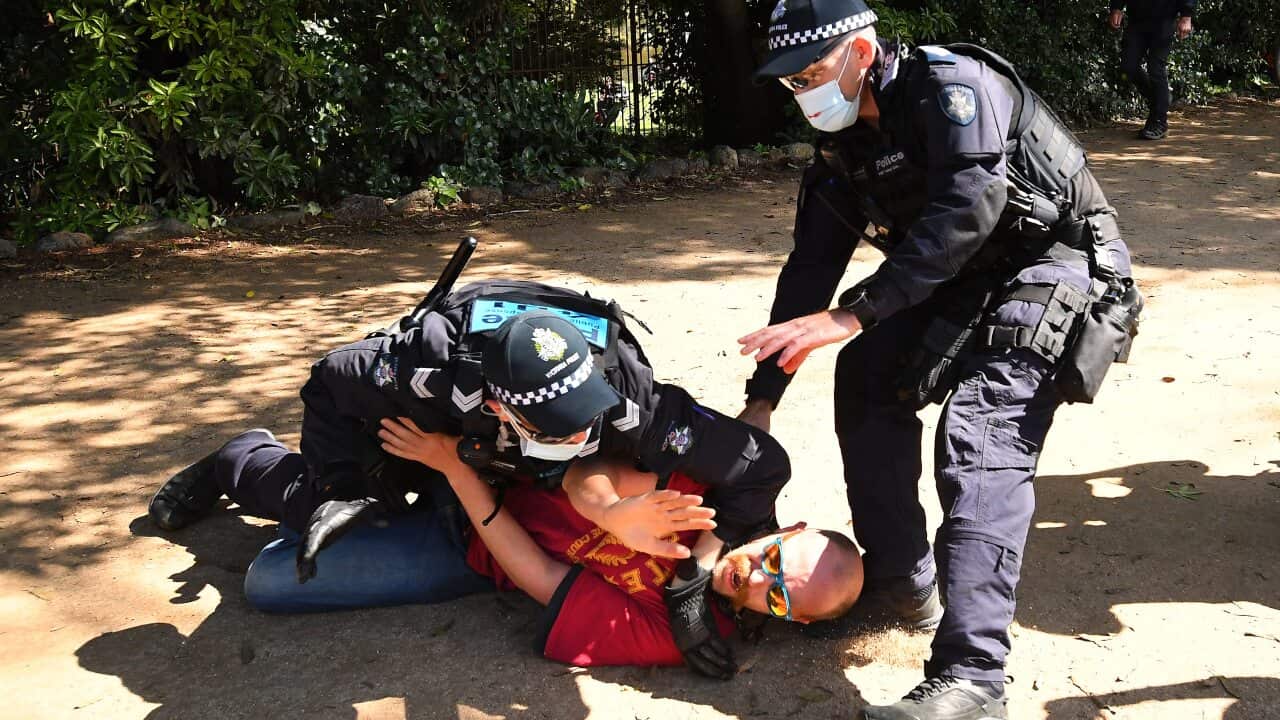 Victoria Police detain a protester near the Royal Botanic Gardens during a protest in Melbourne, Saturday, October 2, 2021. (AAP Image/James Ross) NO ARCHIVING