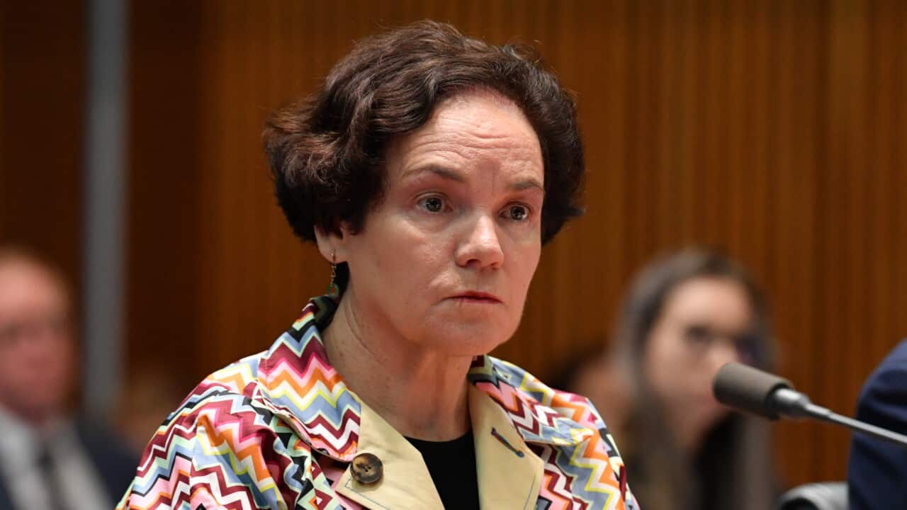 Kathryn Campbell in front of a microphone.