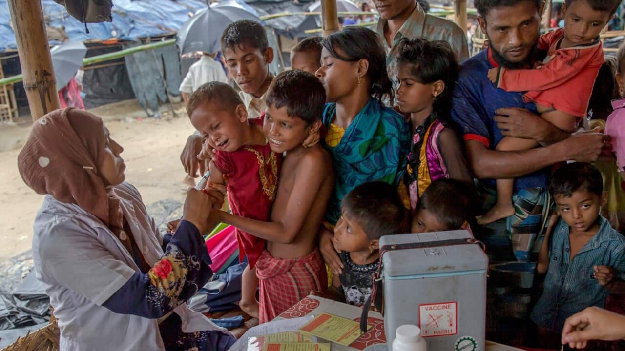 In this Sept. 17, 2017, a Bangladeshi health worker injects vaccine to a Rohingya Muslim boy, who crossed over from Myanmar into Bangladesh