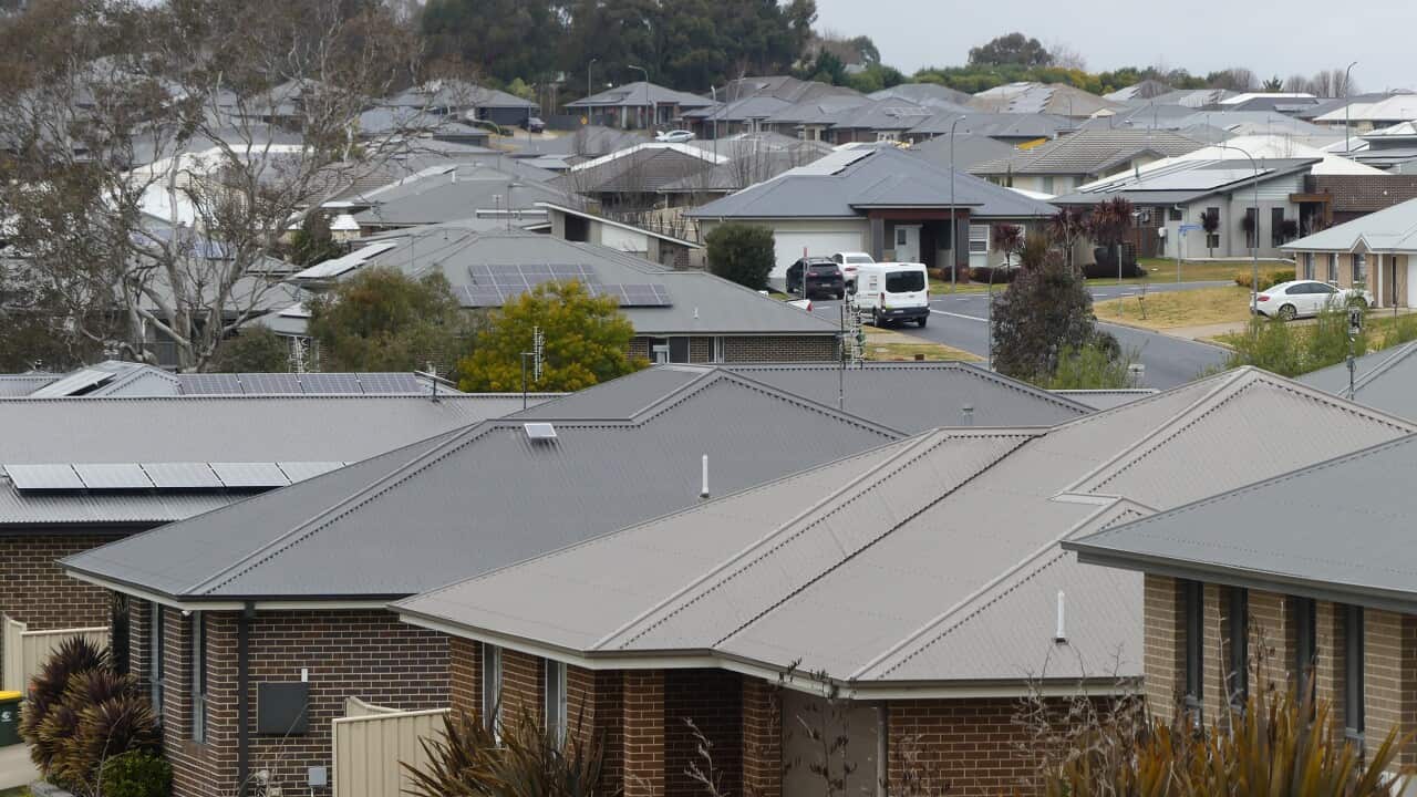 A row of houses with grey roofs in a suburban street.