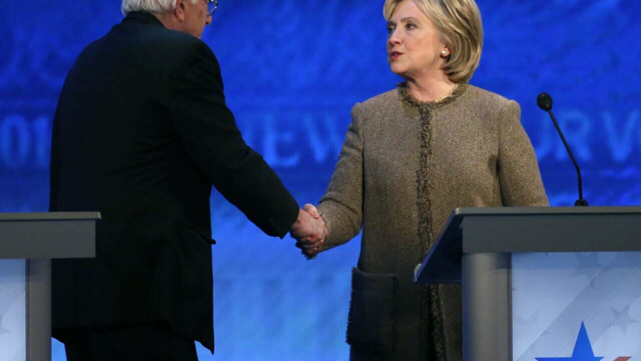 Bernie Sanders, left, speaks to Hillary Clinton