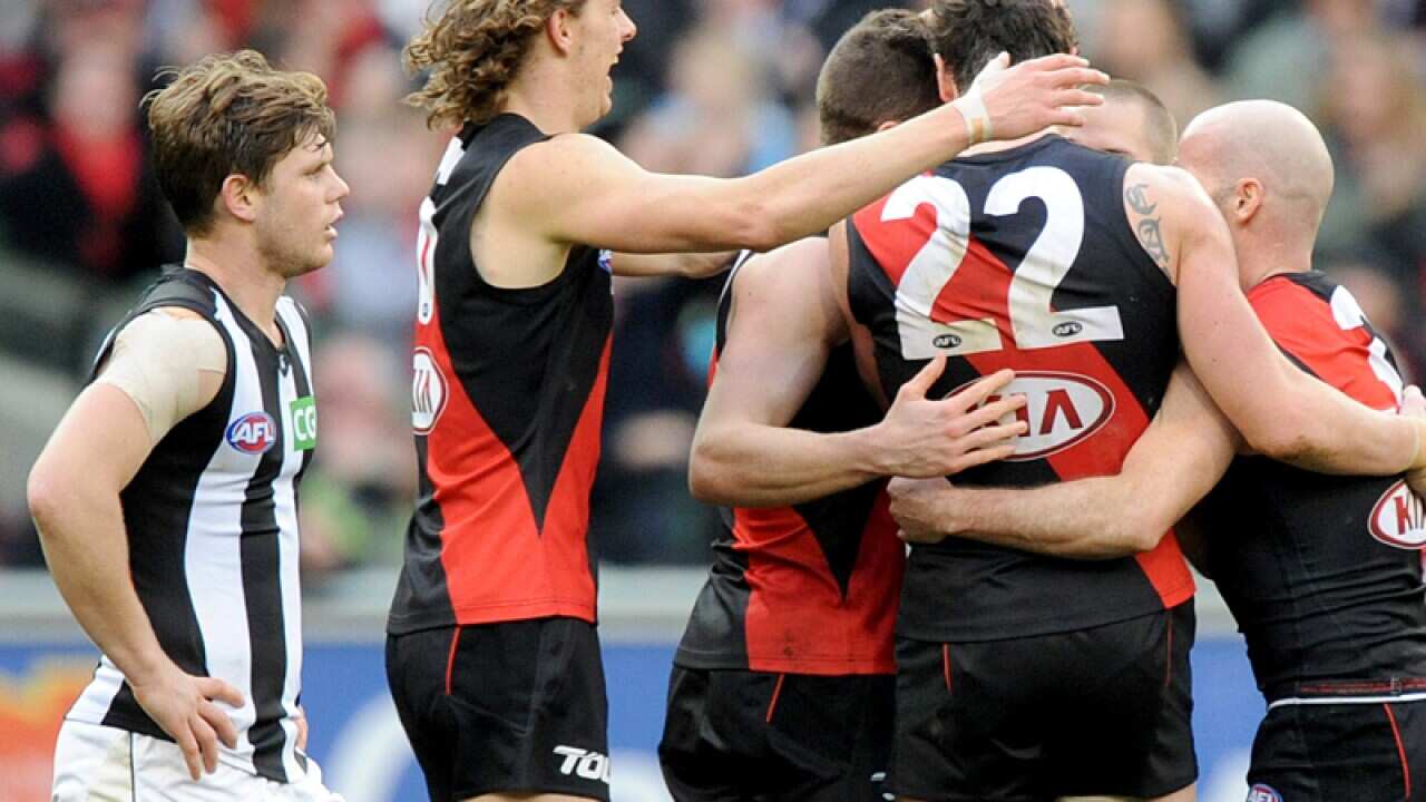 Essendon players celebrate their win against the Magpies