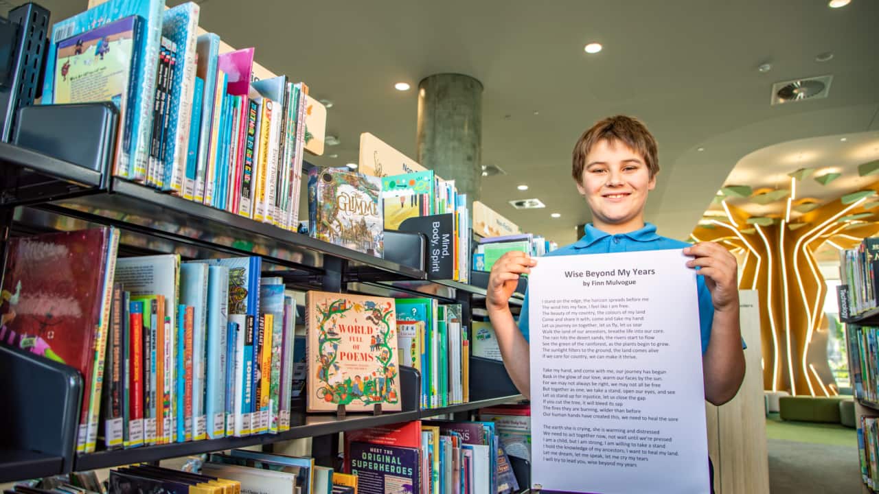 Finn Mulvogue holds a copy of his winning poem, "Wise beyond my years".