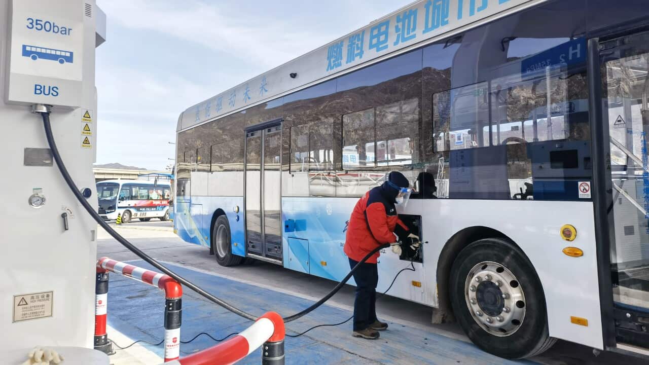A person is seen refuelling a hydrogen-powered bus.