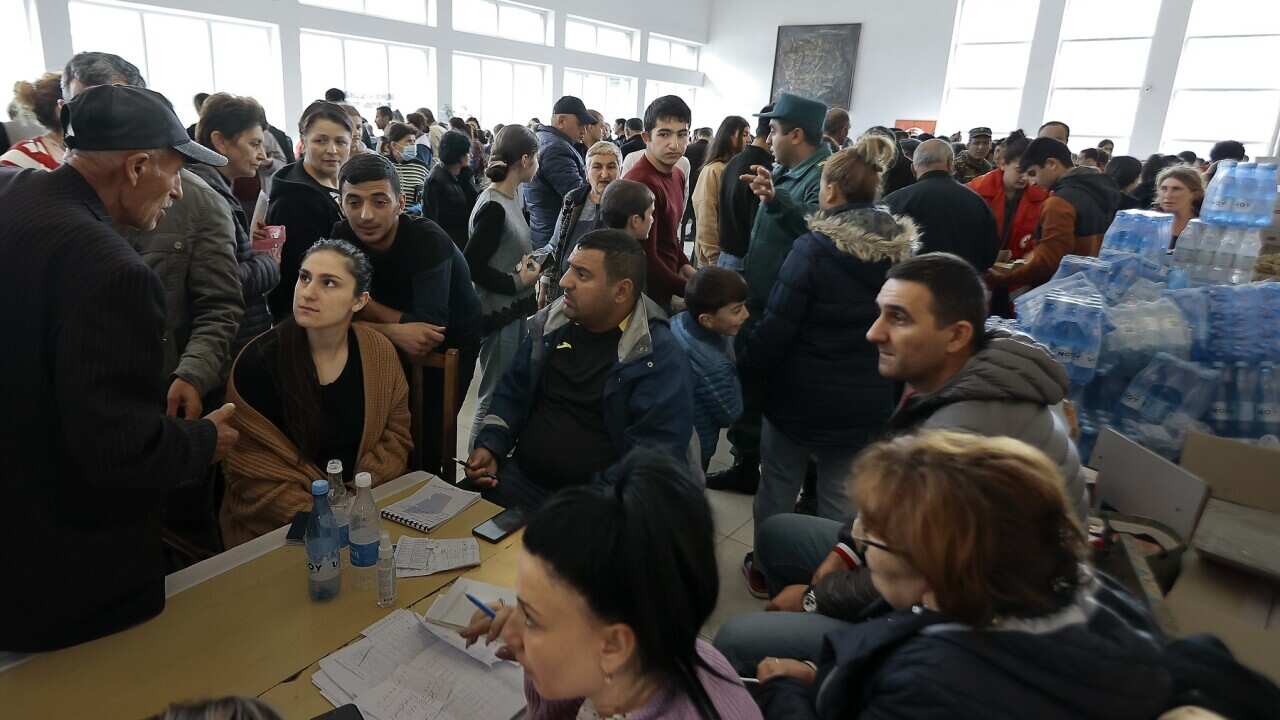 Ethnic Armenians who fled Nagorno-Karabakh line up to receive humanitarian aid