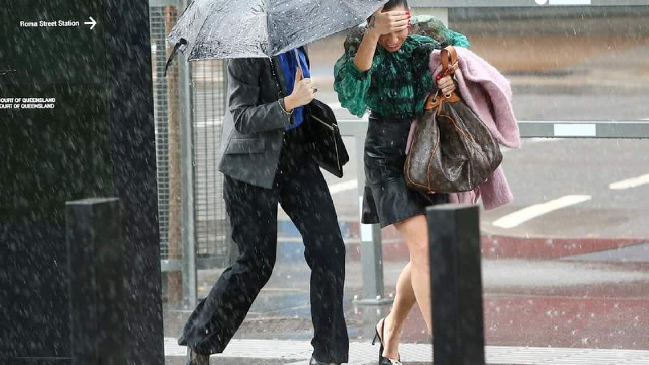 Pedestrians run through rain in Brisbane.