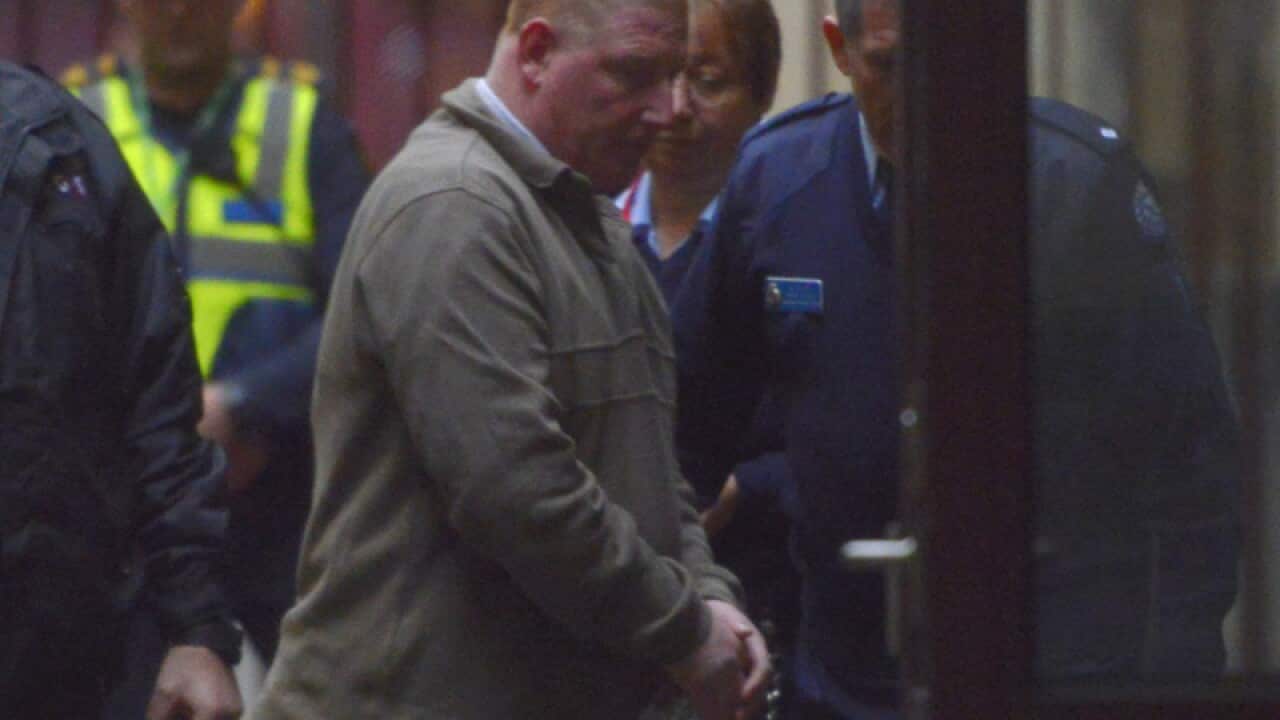 Torsten Trabert (R) is escorted at the Supreme Court of Victoria