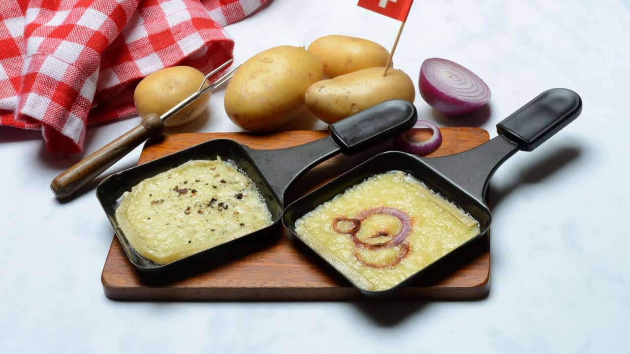 Raclette, melted raclette cheese in pans and ingredients, Switzerland