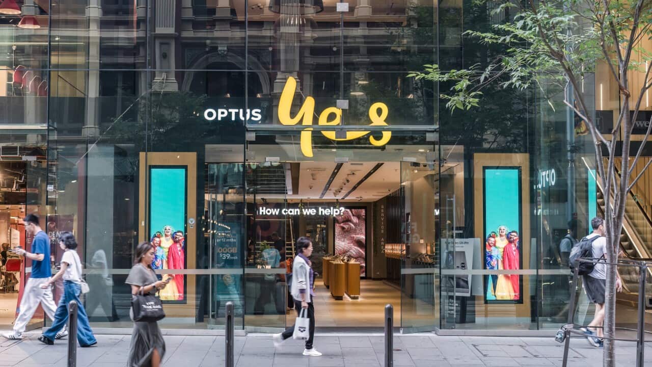 People Walk Past The Optus Mobile Store With A Glass acade