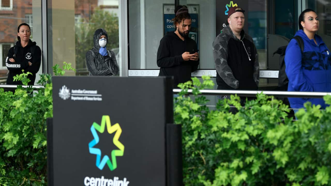 People are seen queuing outside a Centrelink office in Bondi Junction, Sydney, Tuesday, March 24, 2020.