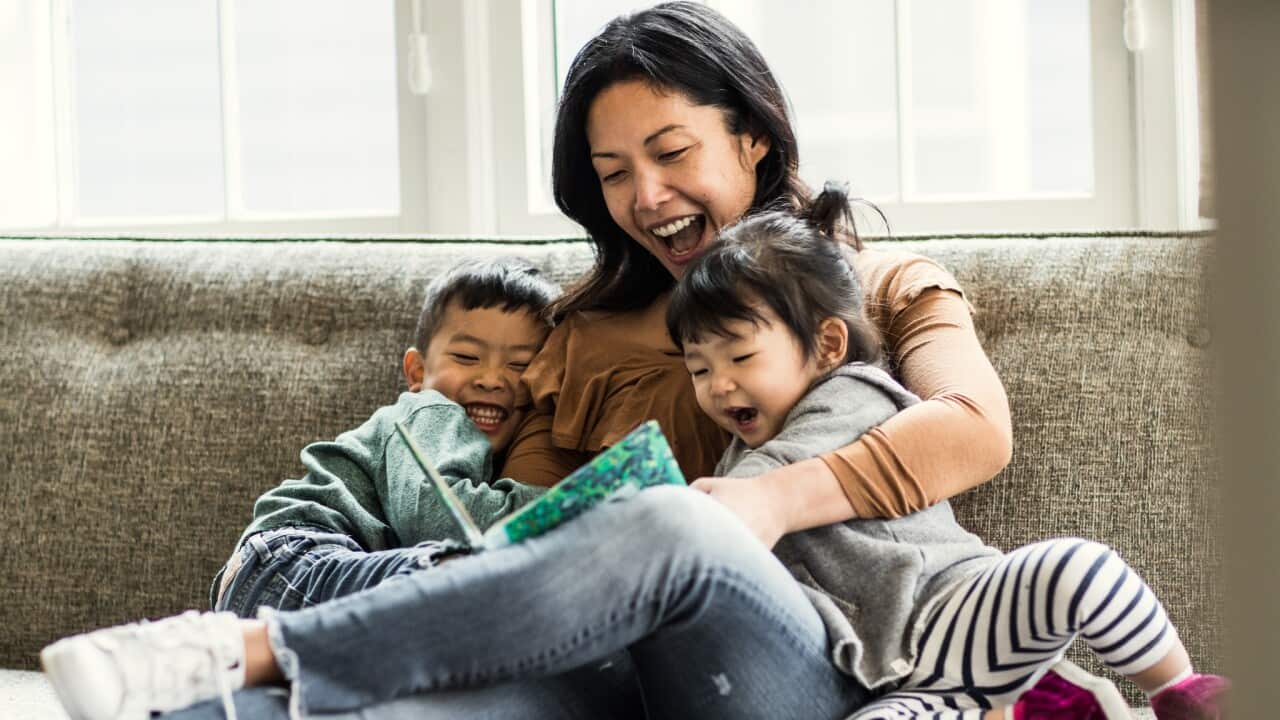 Mother reading to kids on couch