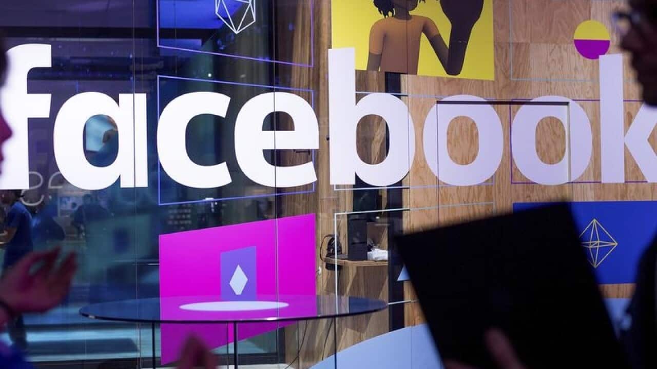 Conference workers in front of a demo booth at a Facebook conference