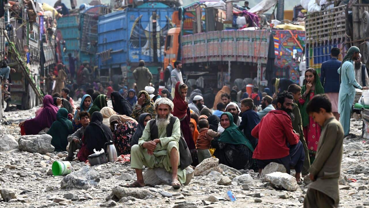 A group of people in Afghan dress sitting on the ground.