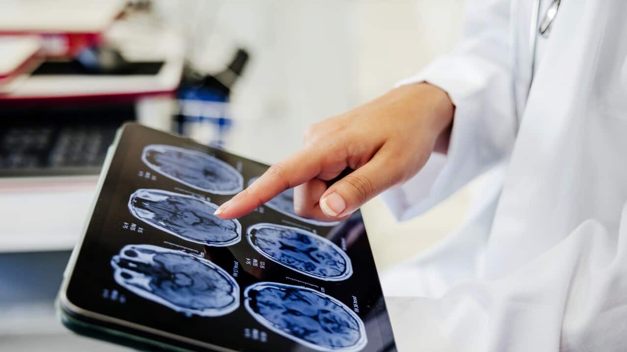 Close-up Shot of a Doctor's Hand Pointing on Brain Scan Images on Digital Tablet