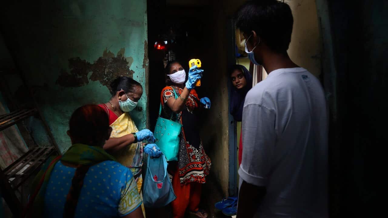 A health worker screen people for COVID-19 symptoms at Dharavi, one of Asia's biggest slums, in Mumbai, India.